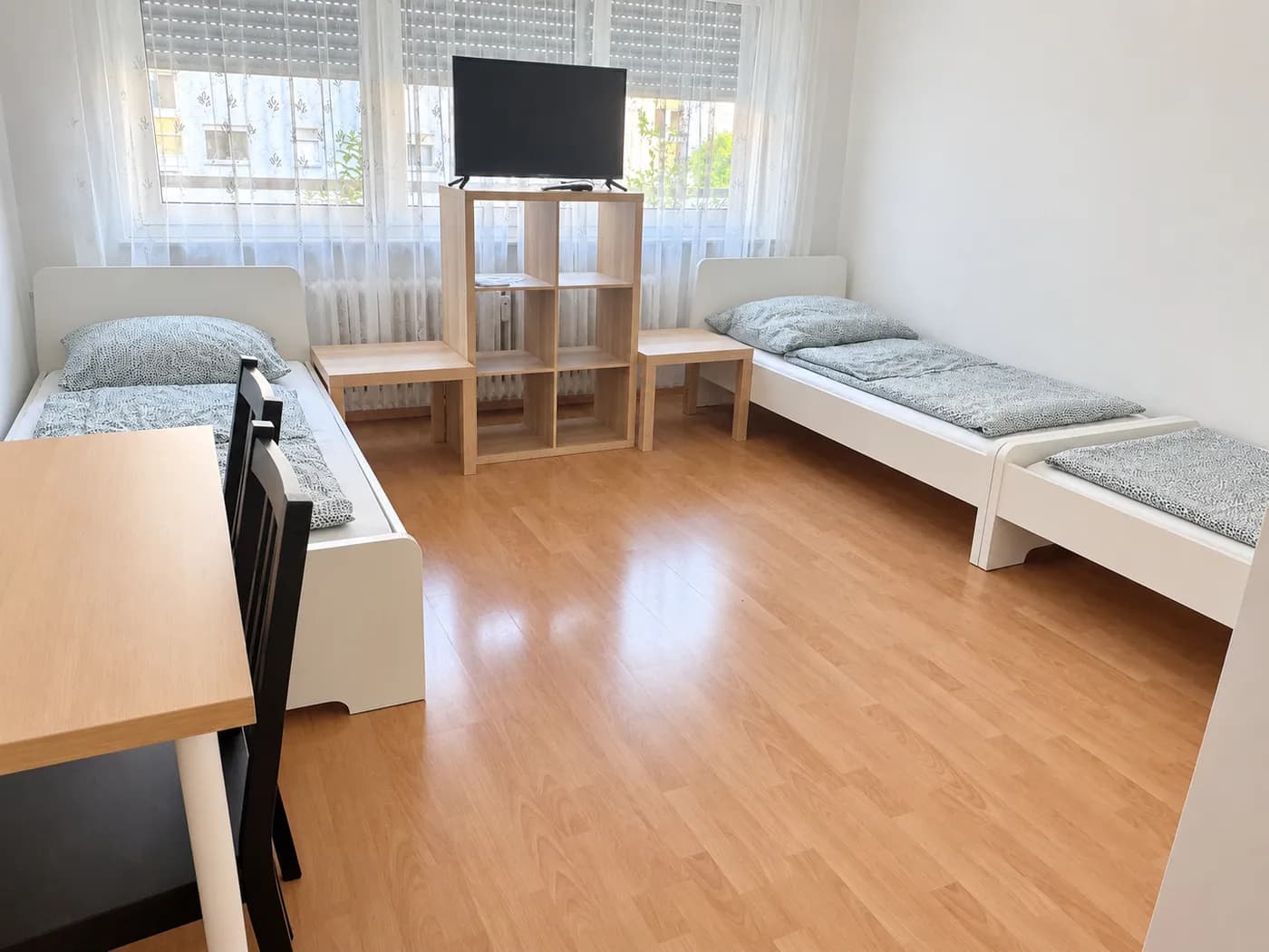 Zwei Einzelbetten mit Tischplatz im Zimmer einer Wohnung