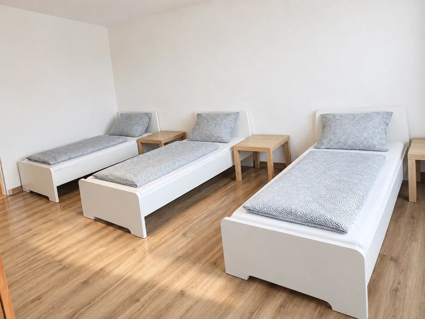 Schlafzimmer mit drei getrennten Einzelbetten in einer Hometime24 Wohnung in Krefeld