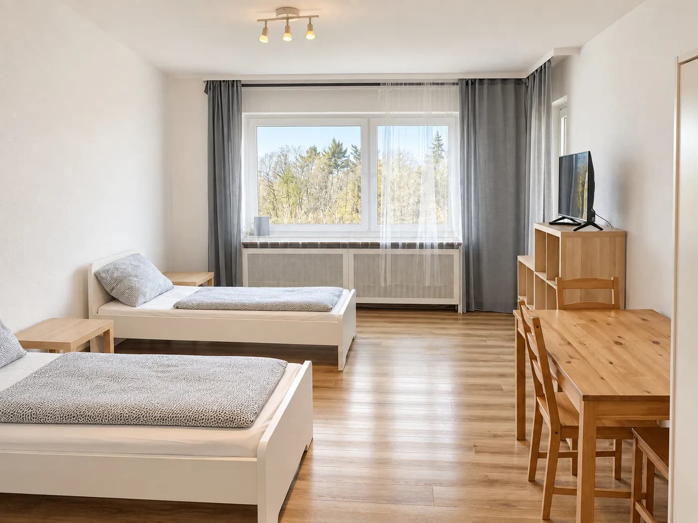 Zimmer mit Einzelbetten, Esstisch und Fernseher in derselben Wohnung in Krefeld