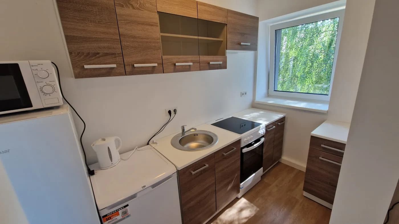 Moderne Küchenzeile mit Herd, Backofen, Mikrowelle und Kühlschrank in einer Monteurwohnung im Raum Landshut