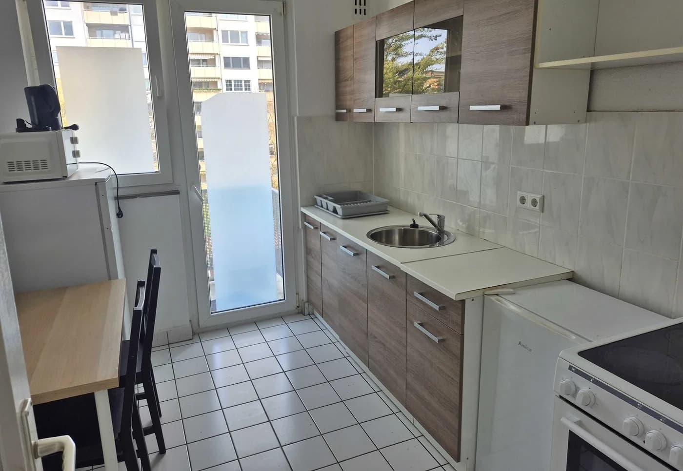 Voll ausgestattete Küche mit Herd, Backofen, Kühlschrank und Mikrowelle in einer Monteurwohnung in Neu-Isenburg