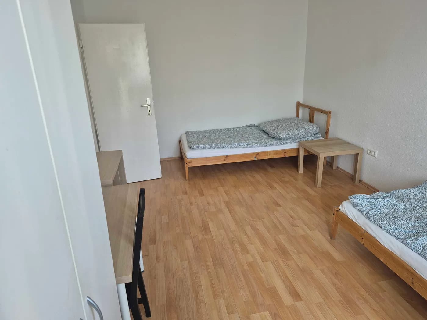 Weiteres ruhiges Zimmer der Monteurunterkunft in Neu-Isenburg mit Einzelbett, Beistelltisch und Schreibtisch