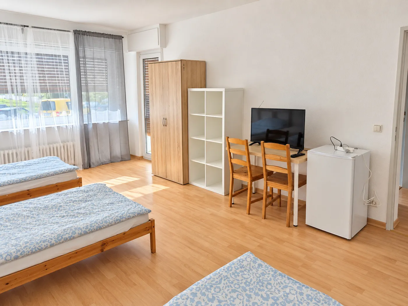 Weitere Ansicht desselben Zimmers mit Tisch und Fernseher