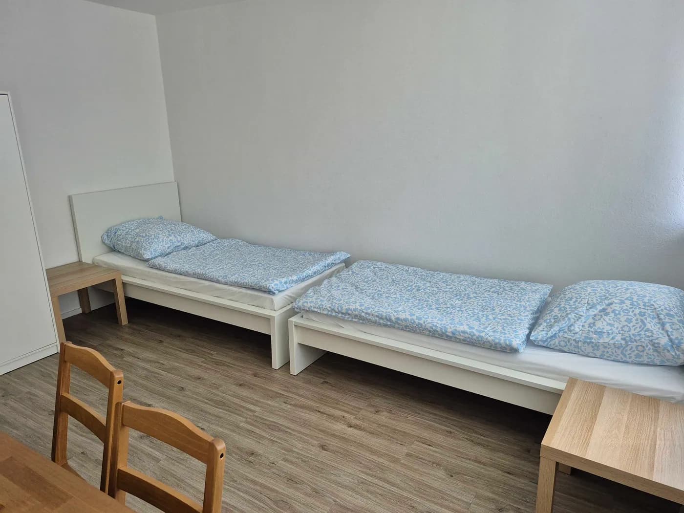 Weiteres Zimmer der Monteurunterkunft in Offenbach mit zwei getrennten Einzelbetten und Nachttischen auf hellem Vinylboden