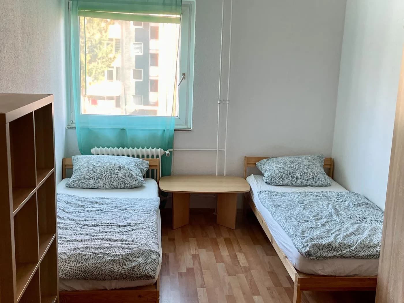 Helles Schlafzimmer einer Monteurwohnung in Wesseling mit zwei getrennten Einzelbetten und großem Fenster