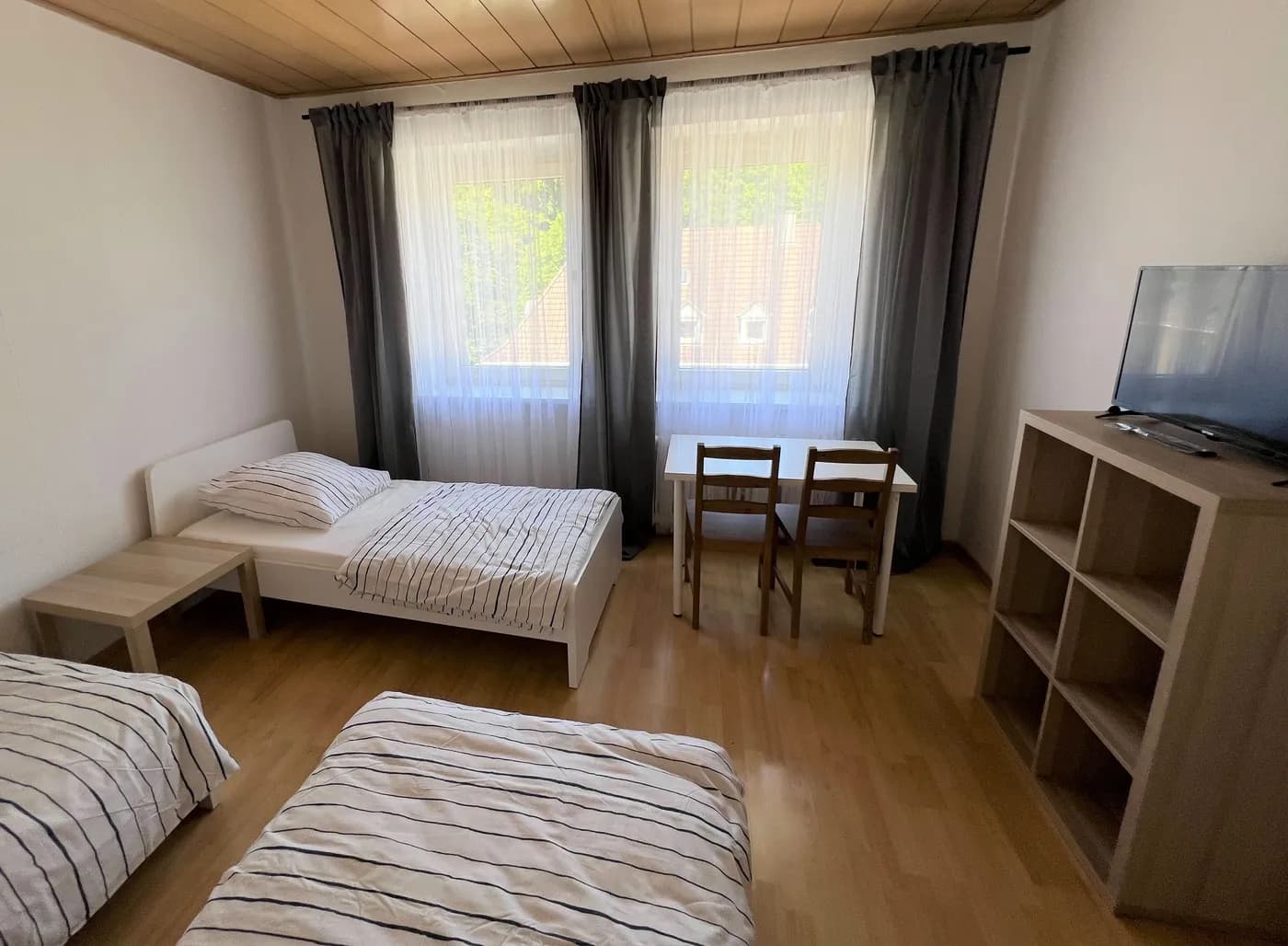 Helles Schlafzimmer einer Monteurwohnung in Wuppertal mit mehreren Einzelbetten