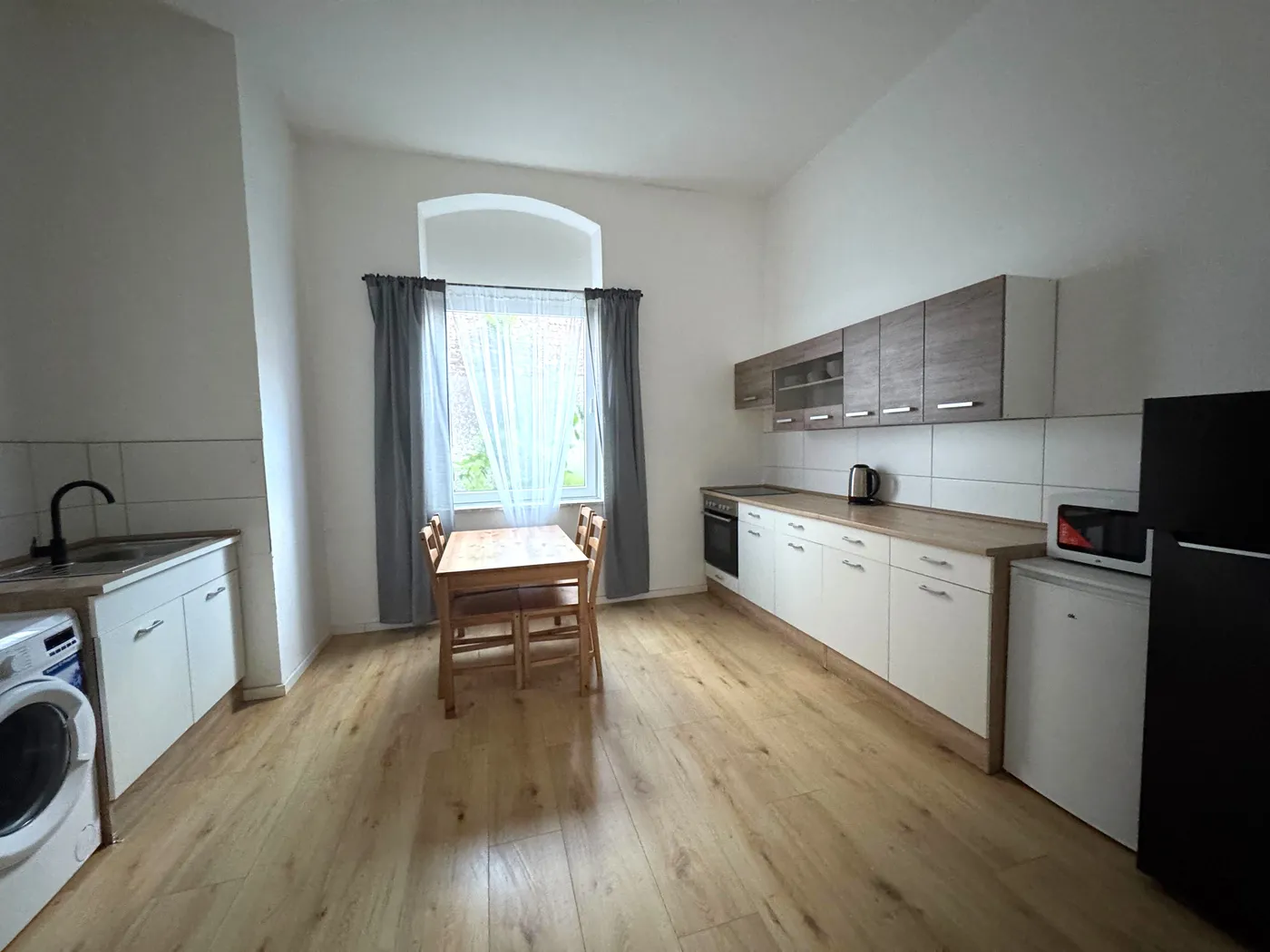Helle Küche mit Esstisch und Backofen in einer Monteurwohnung in Bochum