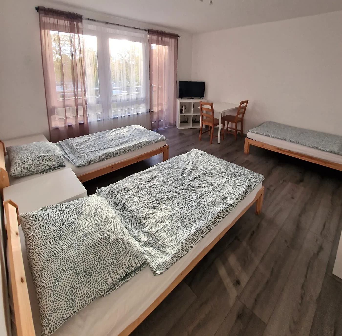 Helles Schlafzimmer einer Monteurwohnung in Dortmund mit drei getrennten Einzelbetten