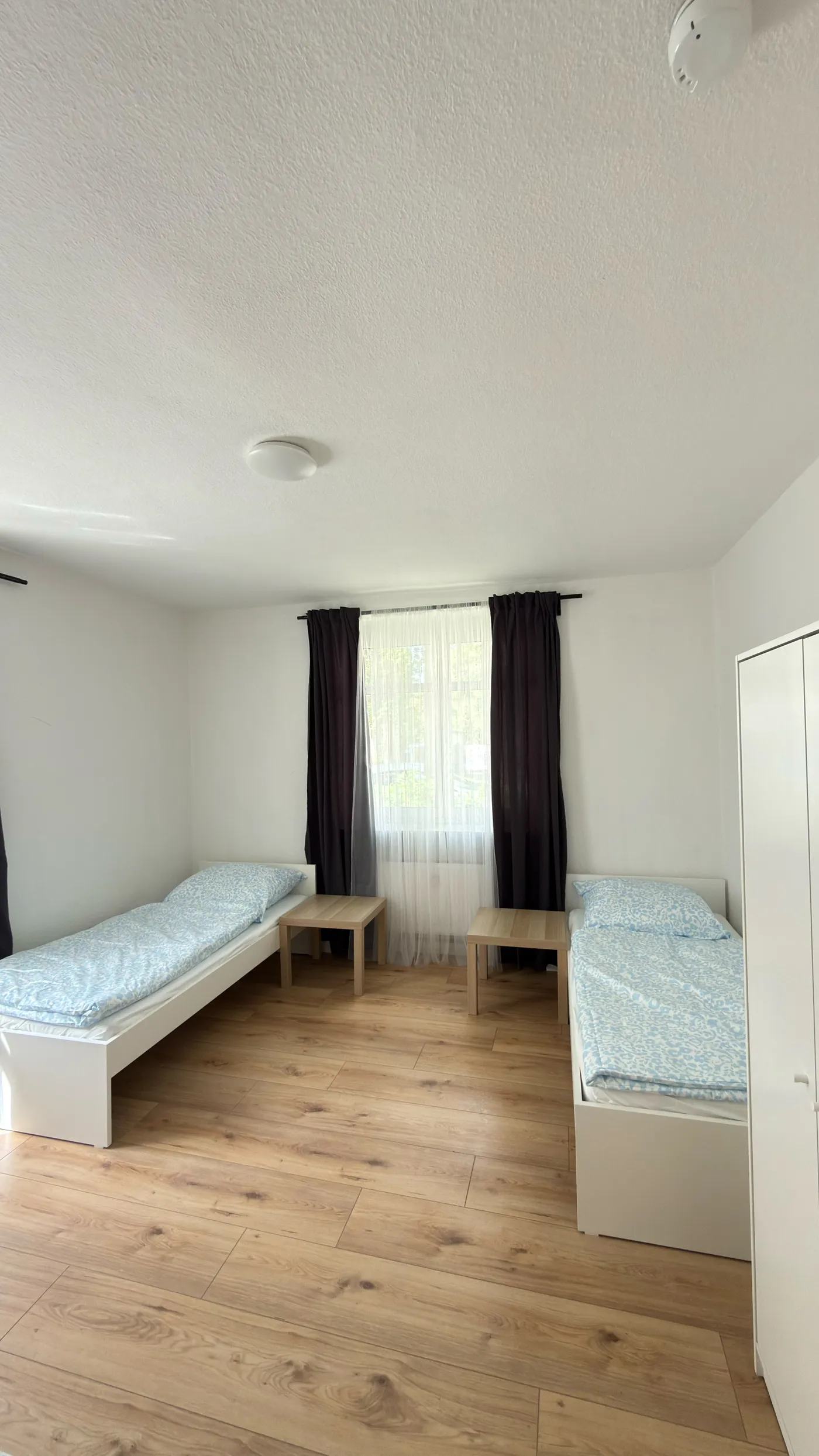 Helles Schlafzimmer einer Monteurwohnung in Dresden mit zwei getrennten Einzelbetten