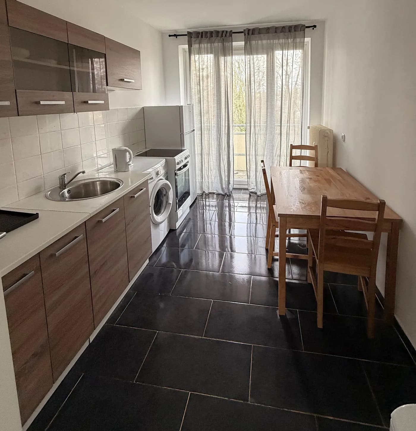 Voll ausgestattete Küche mit Herd, Backofen, Waschmaschine und Essplatz in einer Monteurwohnung in Eschweiler