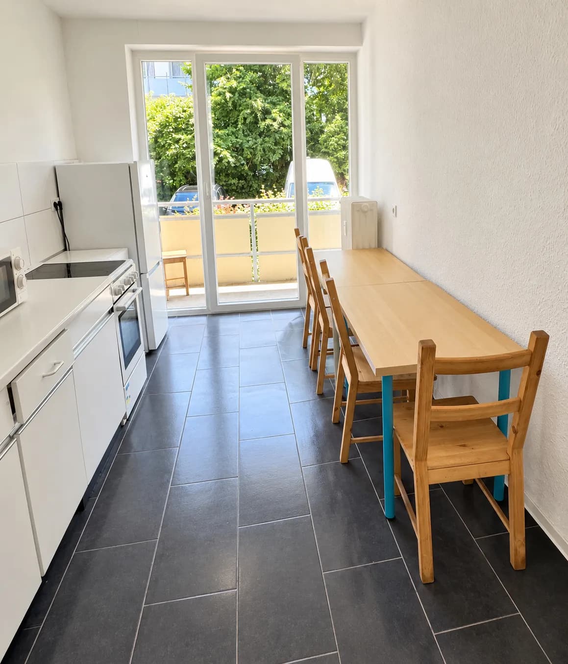 Weiße Küche derselben Wohnung mit Herd und Essplatz