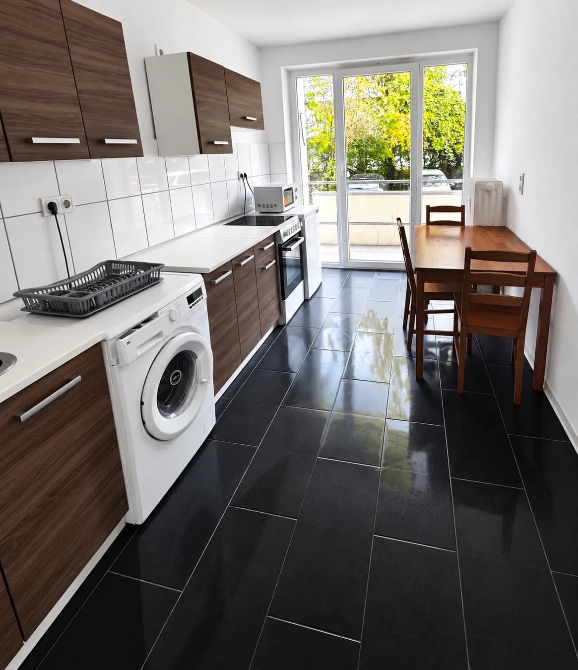 Küche mit Holzfronten und Waschmaschine in derselben Wohnung