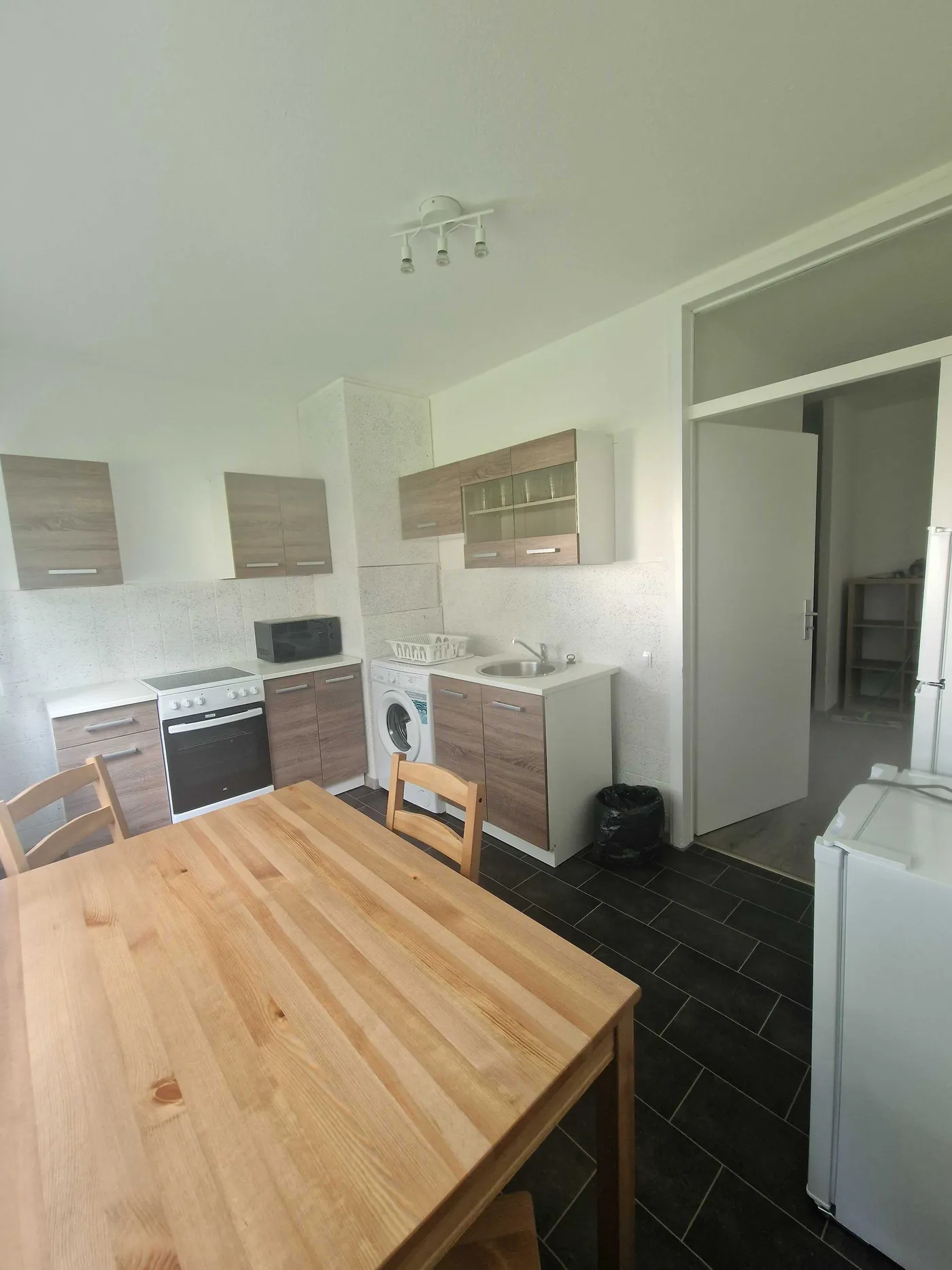 Ausgestattete Küche mit Herd, Backofen und Esstisch in einer Monteurwohnung in Hagen