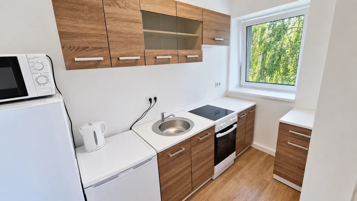 Eigene Küche mit Herd und Kühlschrank im Apartment in Kösching