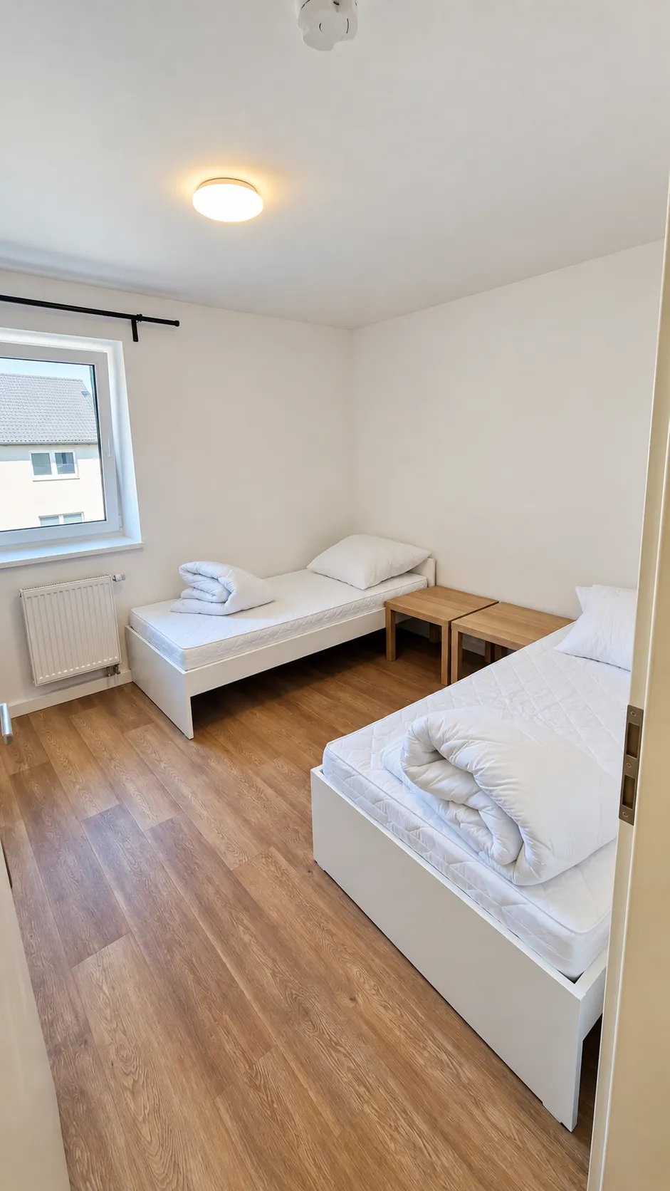 Zwei getrennte Einzelbetten im zweiten Schlafzimmer der Wohnung in Kösching