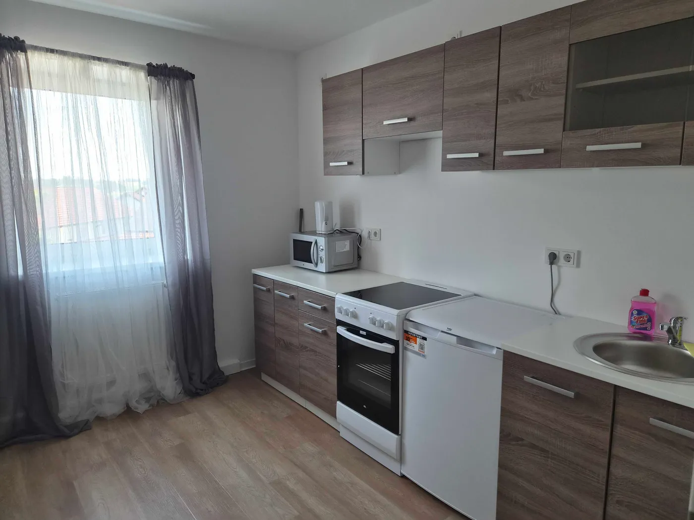 Küchenzeile mit Herd und Kühlschrank in der Wohnung in Kösching