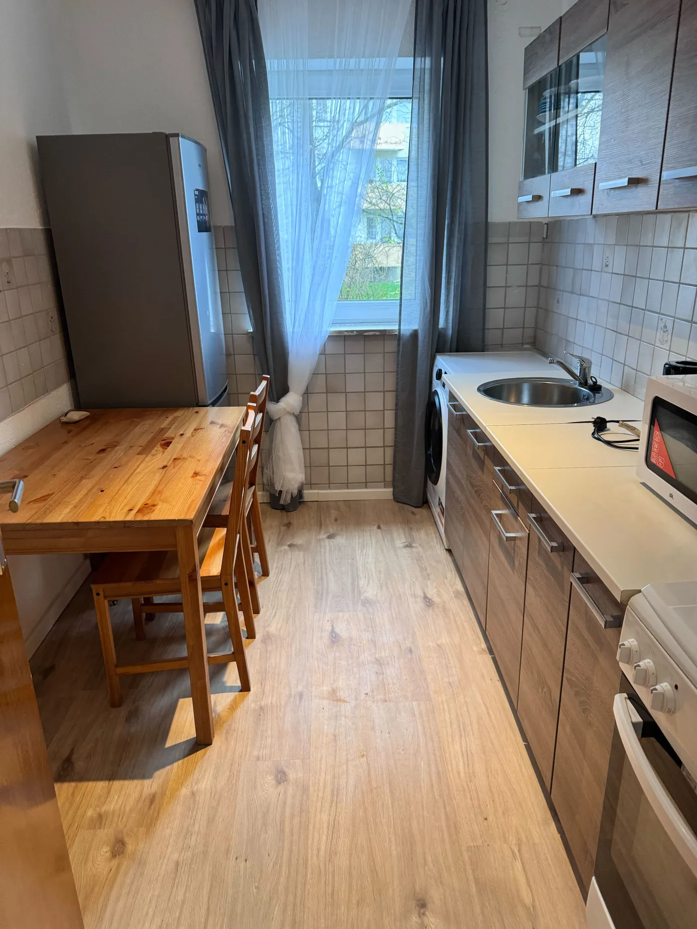 Helle ausgestattete Küche mit Herd und Essplatz in einer Monteurwohnung in Leverkusen