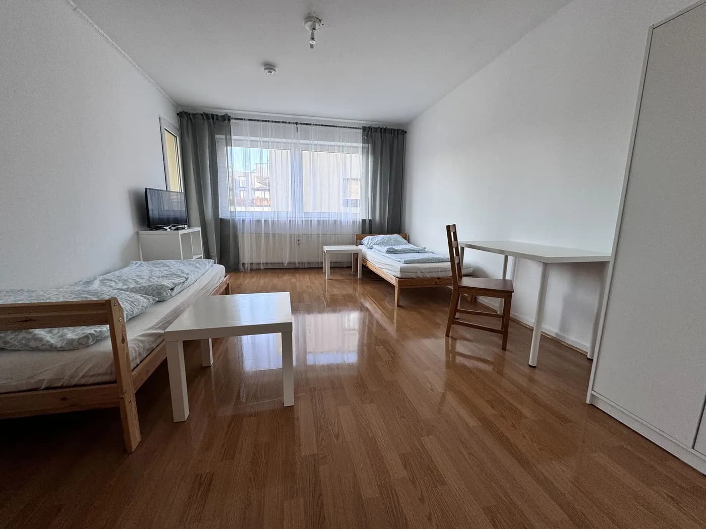 Helles Schlafzimmer einer Monteurwohnung in Leverkusen mit zwei getrennten Einzelbetten