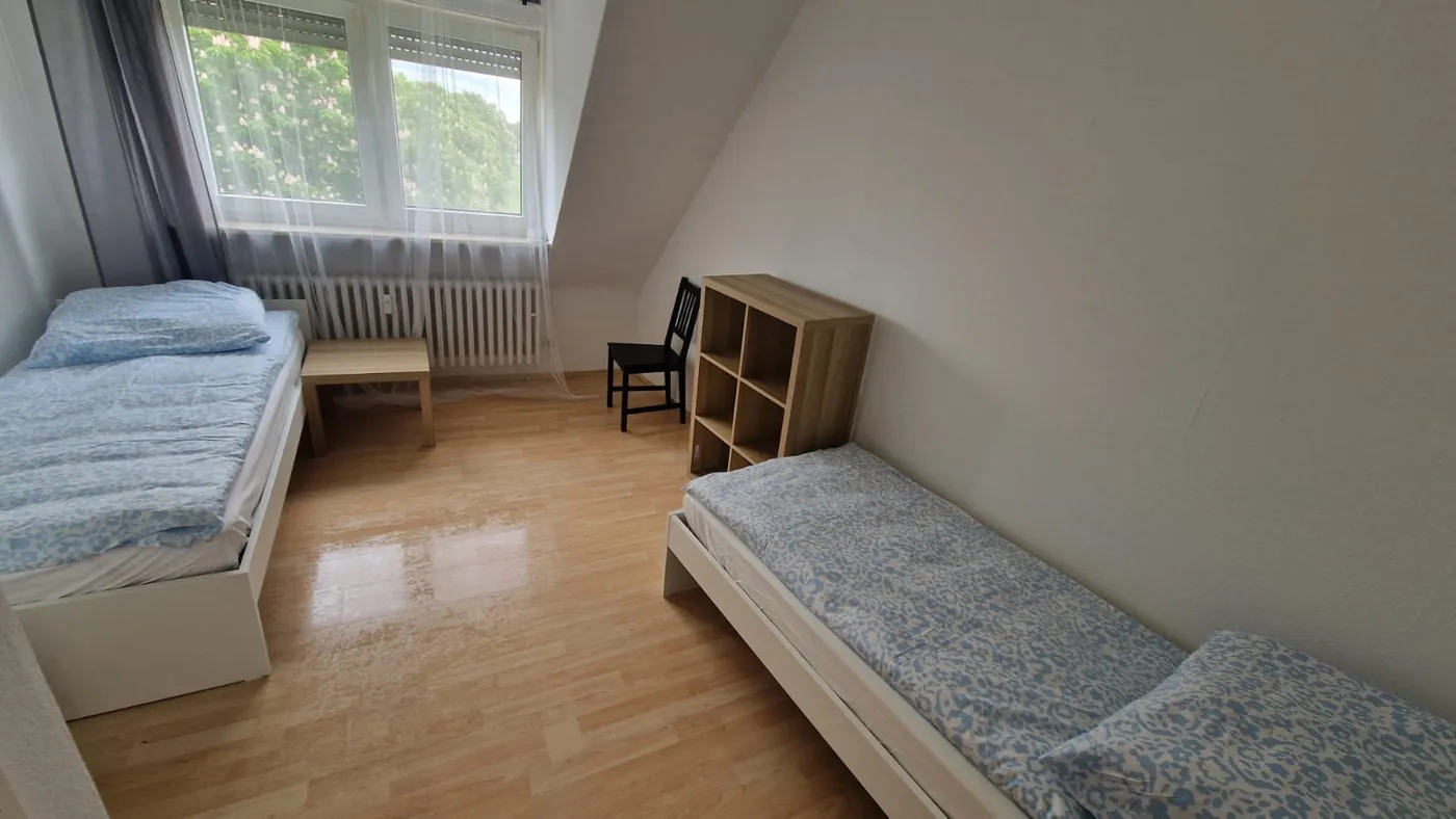 Zweibettzimmer mit Fernseher in einer Monteurwohnung in Ludwigshafen