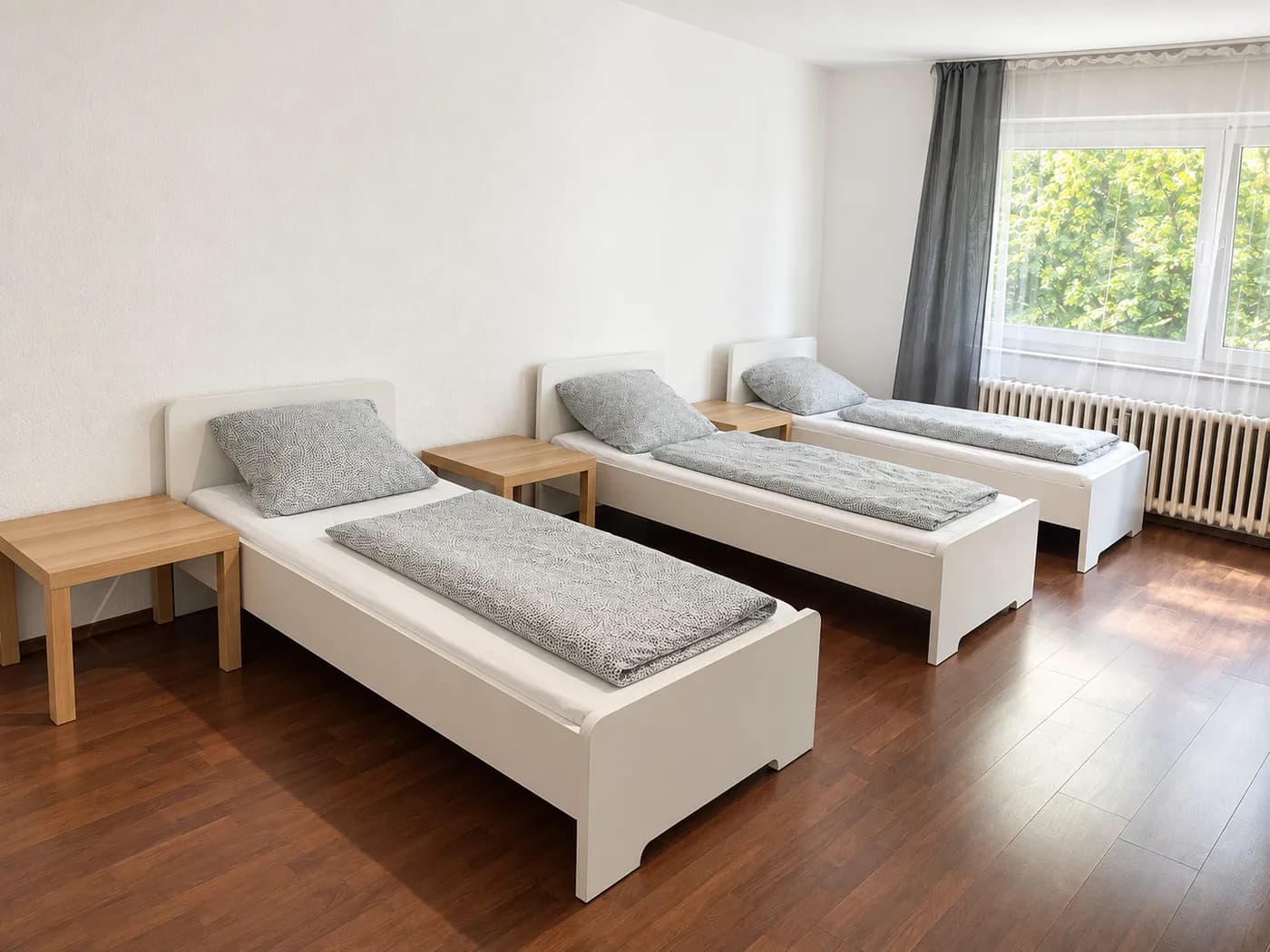 Drei Einzelbetten mit Nachttischen in einer Hometime24 Wohnung an der Max-Planck-Straße in Krefeld