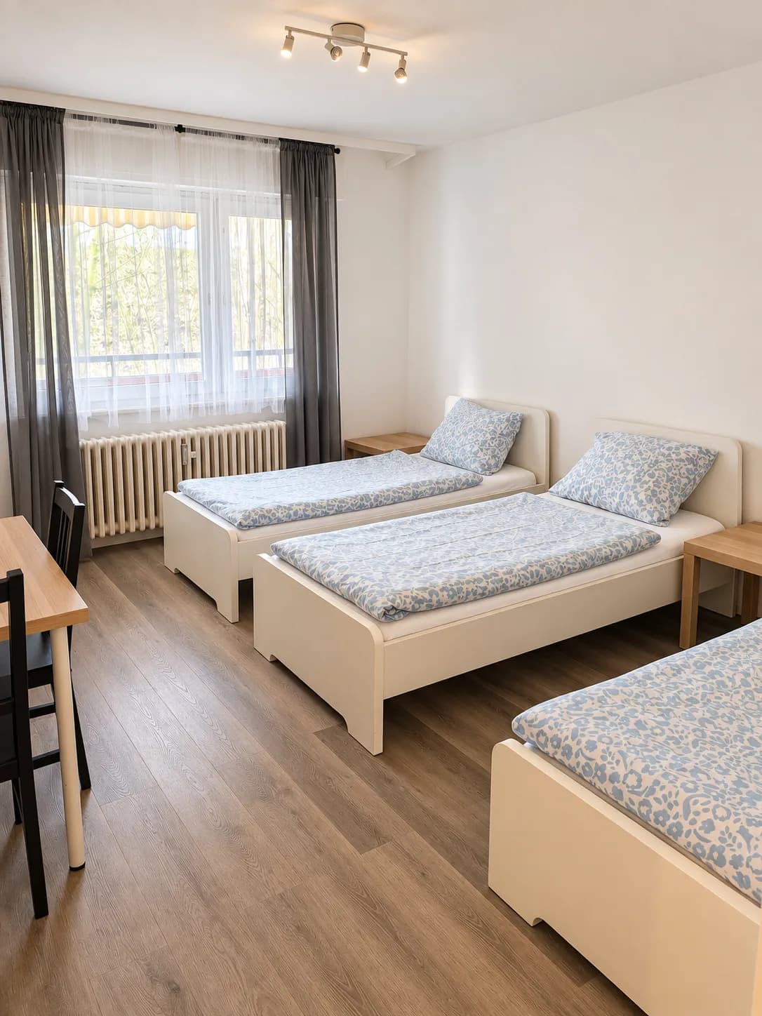 Dreibettzimmer mit Schreibtisch in einer Hometime24 Wohnung im Krefelder Osten