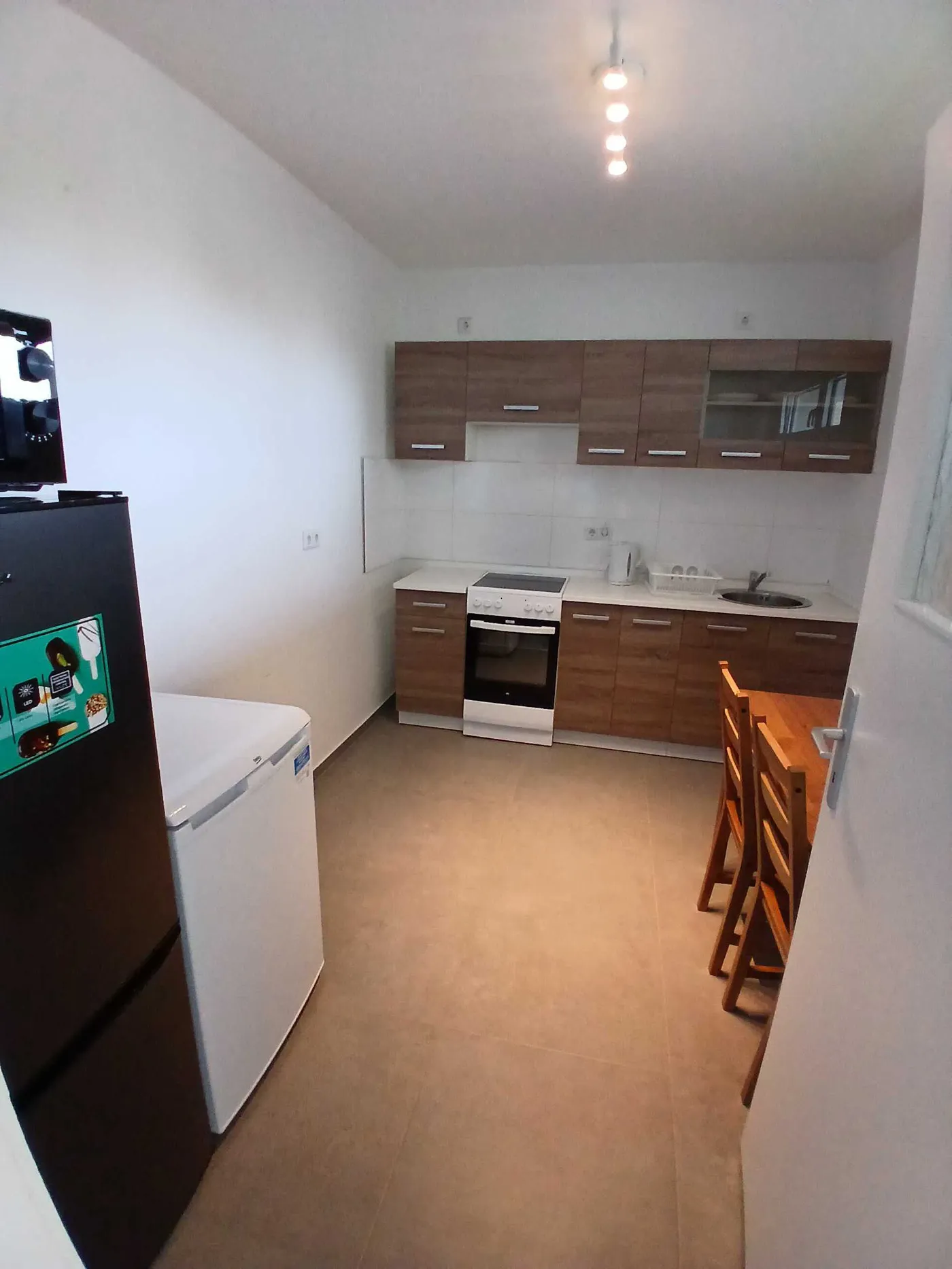Voll ausgestattete Küche mit Herd, Backofen, Kühlschrank und Essplatz in einer Monteurwohnung