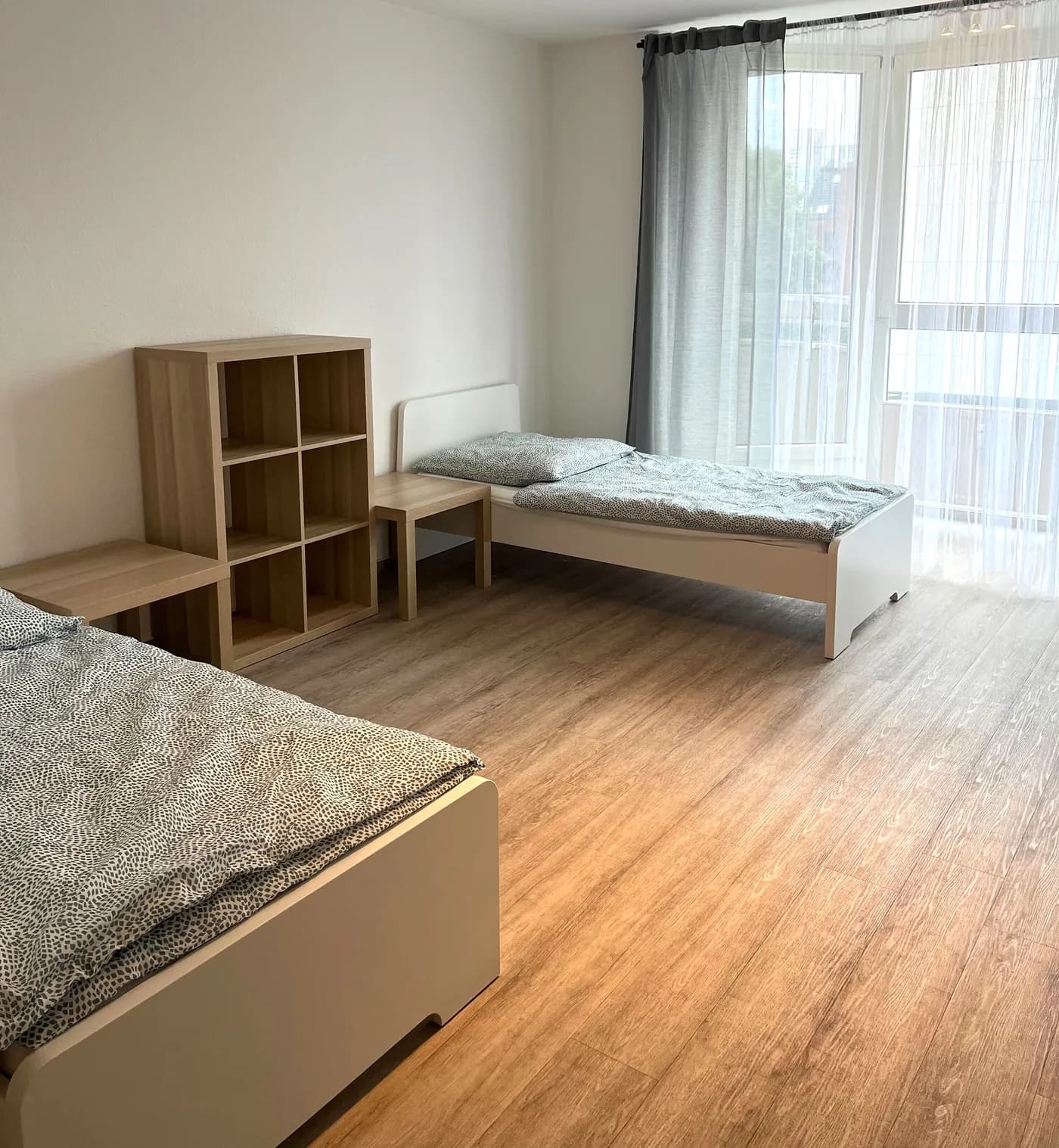 Helles Schlafzimmer einer Monteurwohnung in Neuss mit mehreren getrennten Einzelbetten