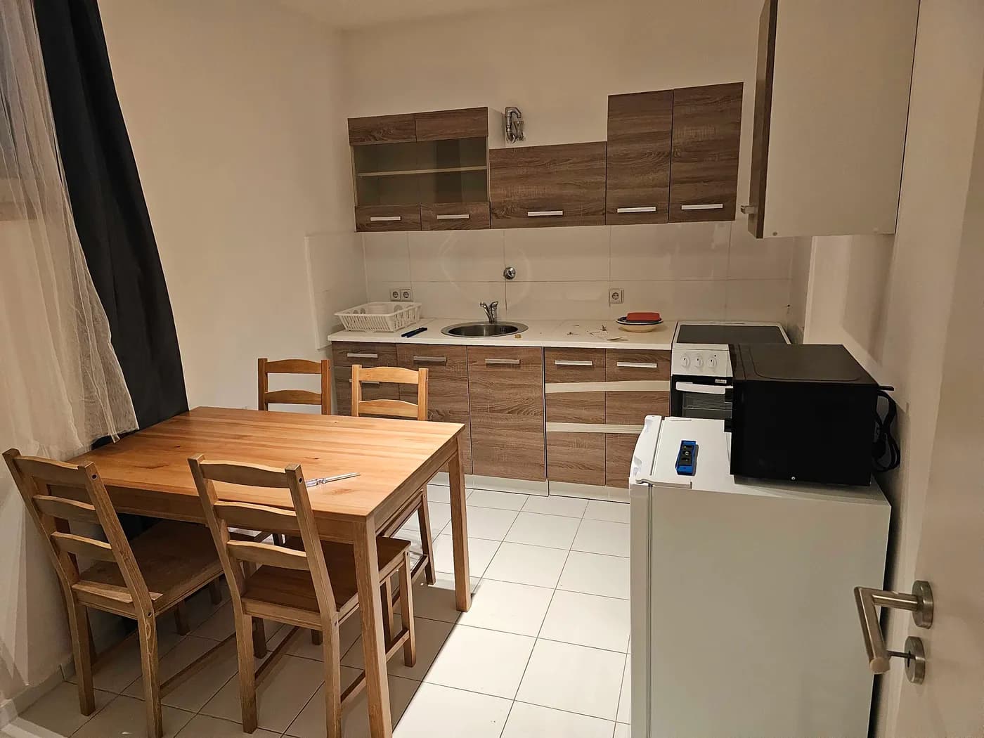 Voll ausgestattete Küche mit Herd, Backofen und Essplatz in einer Monteurwohnung in Ratingen