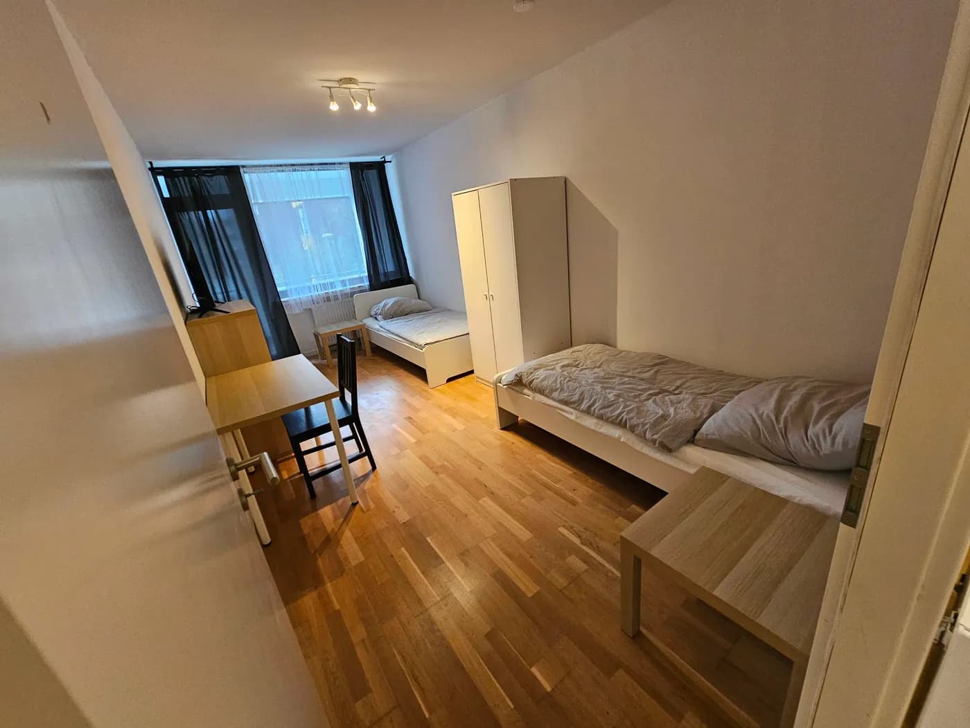Zimmer mit zwei getrennten Einzelbetten und Kleiderschrank in einer Monteurwohnung in Ratingen