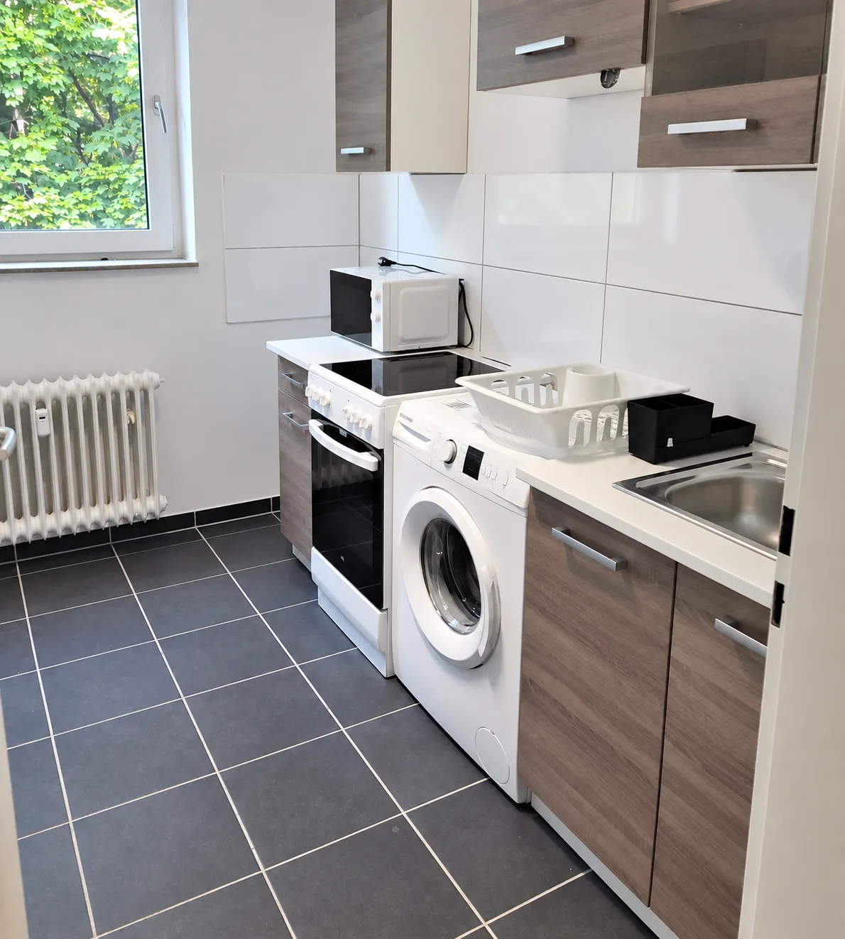 Küche mit Herd, Mikrowelle und Waschmaschine in der Wohnung in Solingen-Mitte