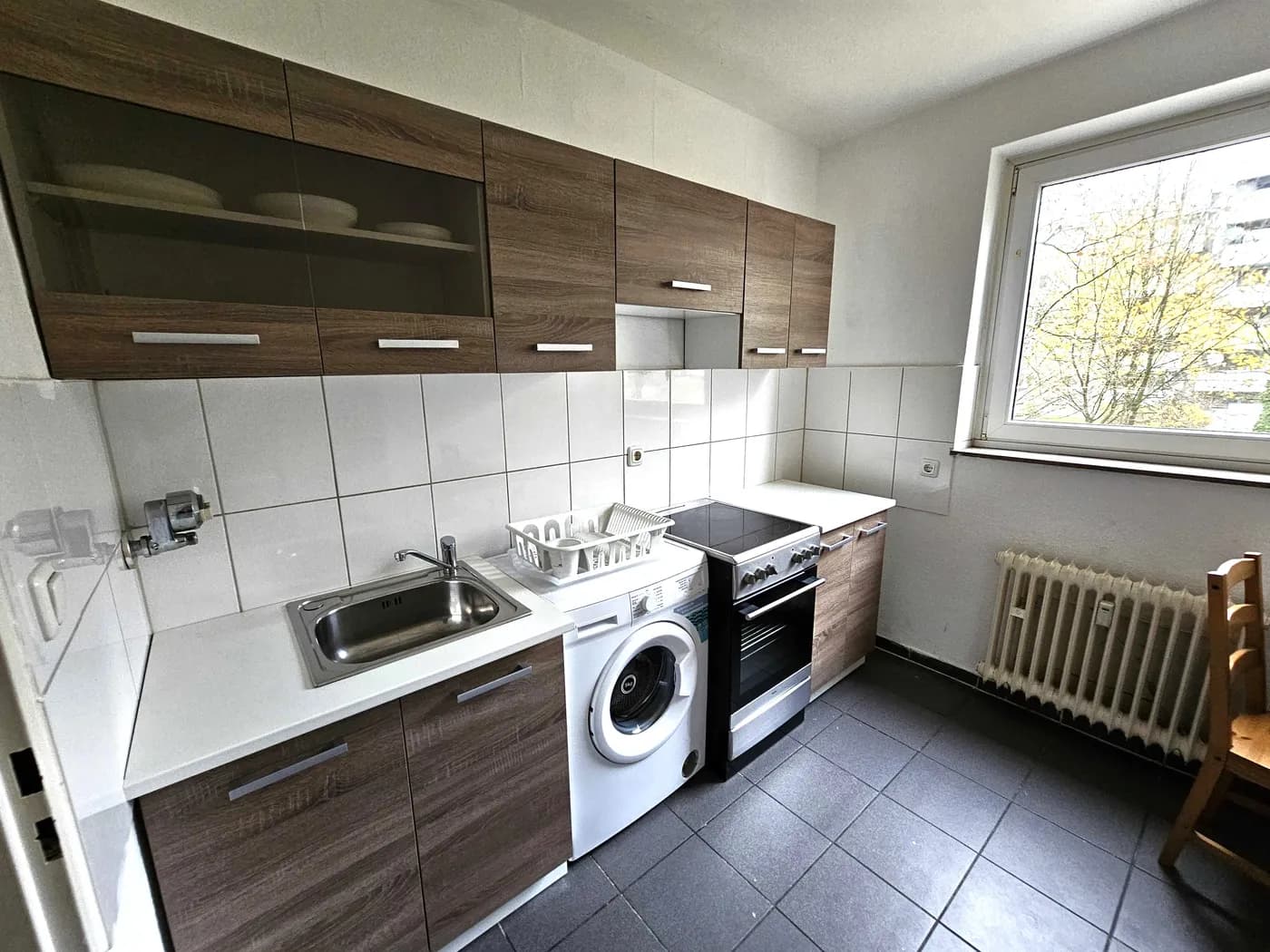 Ausgestattete Küche mit Herd und Waschmaschine in einer Monteurwohnung in Solingen